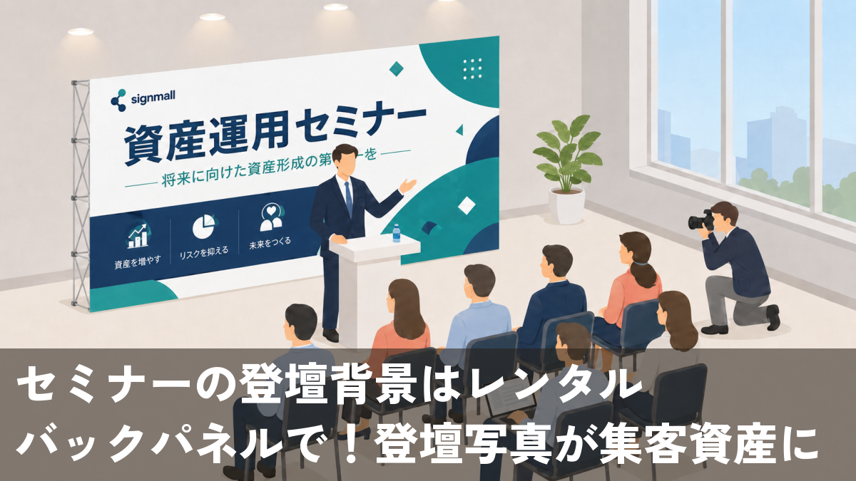 貸会議室で市松ロゴのバックパネルを背に登壇する講師をカメラマンが撮影するセミナー風景