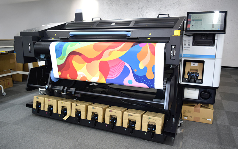 サインモールの工場で稼働する大判プリンター HP Latex R530。カラフルなデザインをにおいの少ない水性ラテックスインクで出力している様子