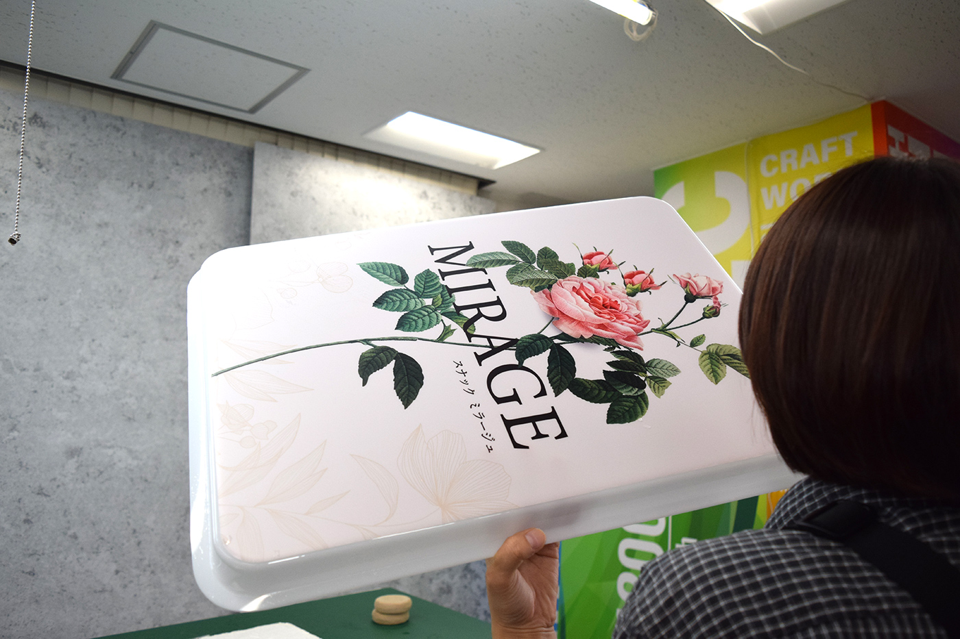 表示面板を照明の光に透かして異物や気泡がないか検品する様子