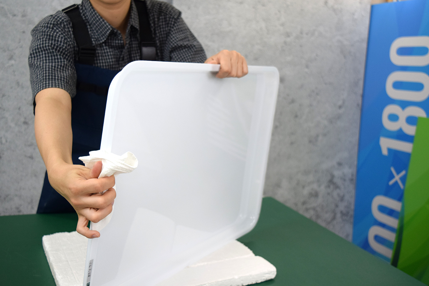 表示面板のフチの立ち上がり部分までウエスで丁寧に拭き上げる様子
