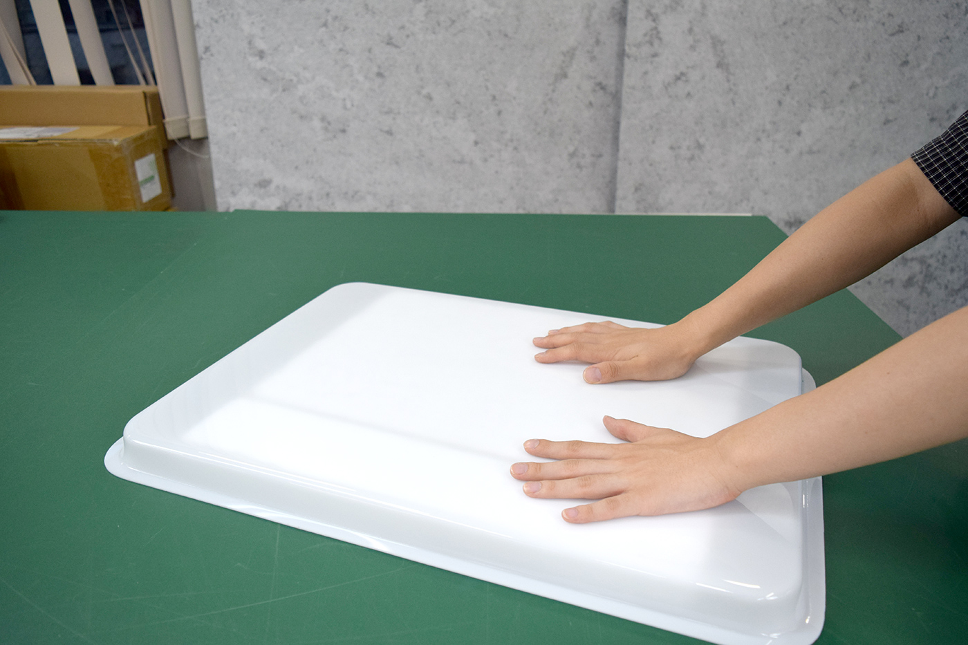 本体から取り出した乳白色のアクリル成型表示面板を作業台に置いた様子