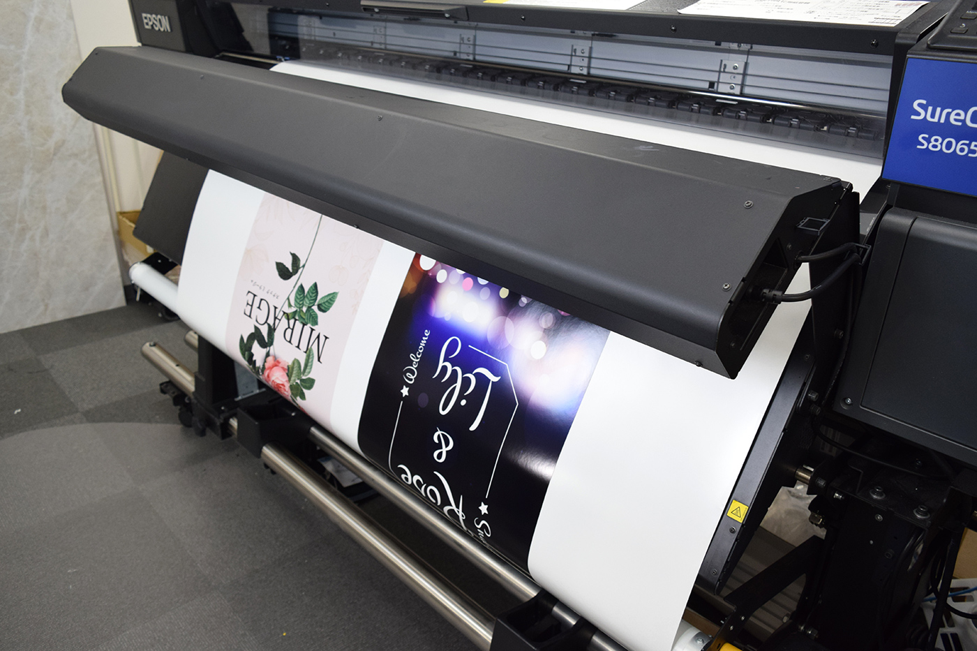 大判溶剤インクジェットプリンターEPSON S80650Lから印刷済みのシートが排出されるところ