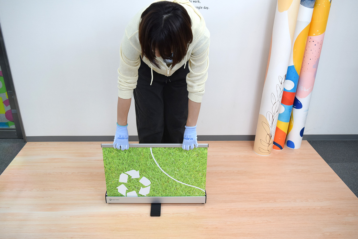 上部バーを持ち、スクリーンをまっすぐ上に引き出し始めた様子