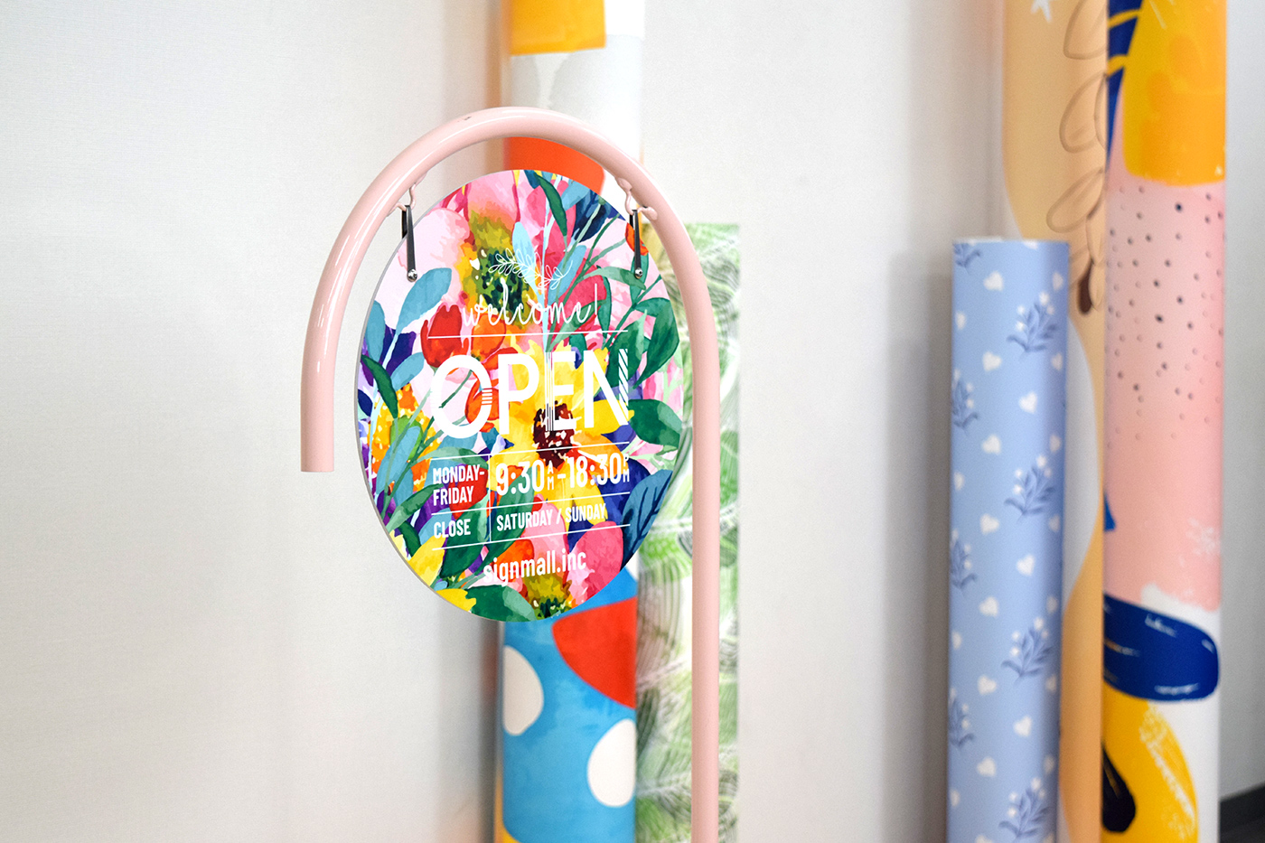 ピンク色の本体にセットした、花柄デザイン面のP型サインスタンド