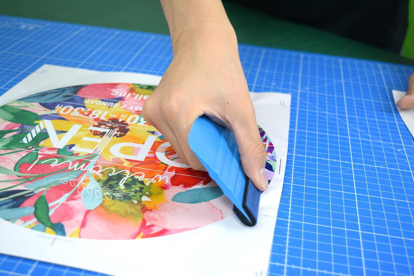 円形の花柄デザイン全体を、スキージーで中心から外へ圧着している様子