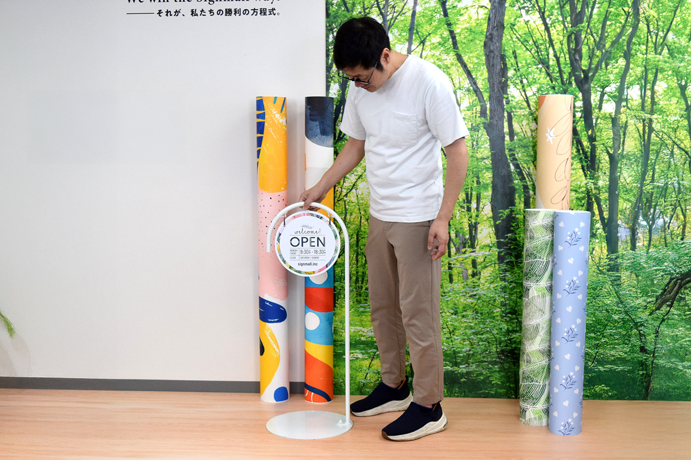 完成したP型サインスタンドをフロアに設置している製作スタッフ