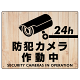 防犯カメラ作動中 白木調背景/黒文字 オリジナル プレート看板 W600×H450 アルミ複合板